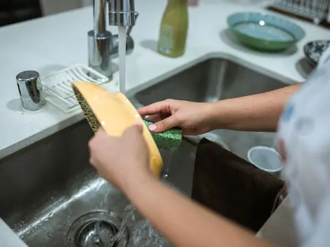 Dishes washed under running water in a kitchen sink