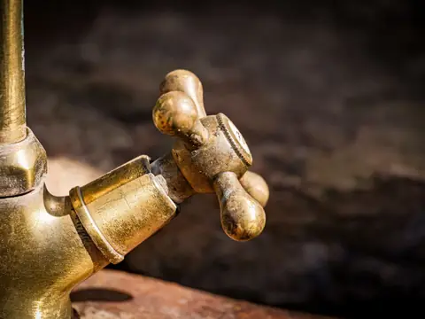 An old brass faucet with worn handles