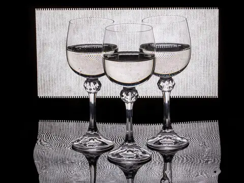 Three crystal glasses of water on a dark table