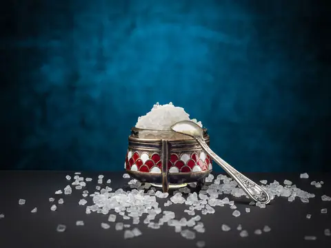 Rock salt in a glass container with a silver spoon